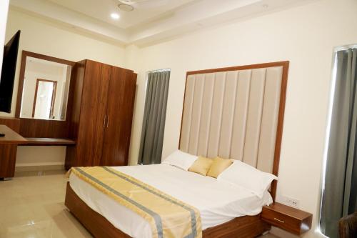 1 dormitorio con 1 cama grande y espejo en MBS BANQUETS en Amritsar