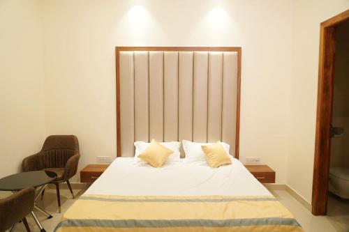 een slaapkamer met een groot wit bed met 2 kussens bij MBS BANQUETS in Amritsar