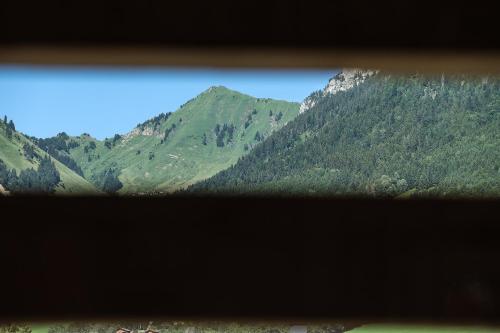a view of a mountain range from a window at 1000 Borne Caffe Hebergements Insolites in Entremont