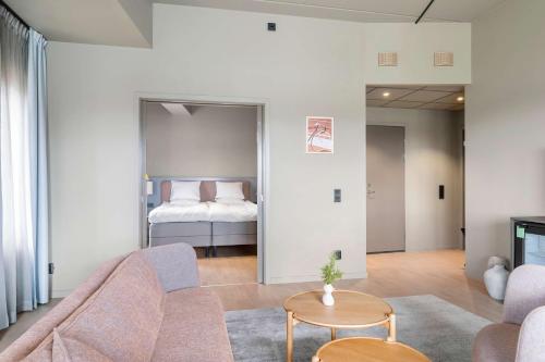 uma sala de estar com um sofá e uma cama em Aiden by Best Western Karlstad Arena em Karlstad