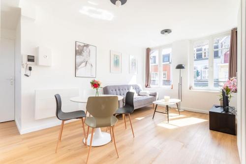 un salon avec une table, des chaises et un canapé dans l'établissement Bel Appartement Cosy proche du métro - Lille, à Lille