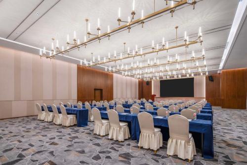 a conference room with a blue table and chairs at Hilton Garden Inn Huzhou High-Speed Railway Station in Huzhou