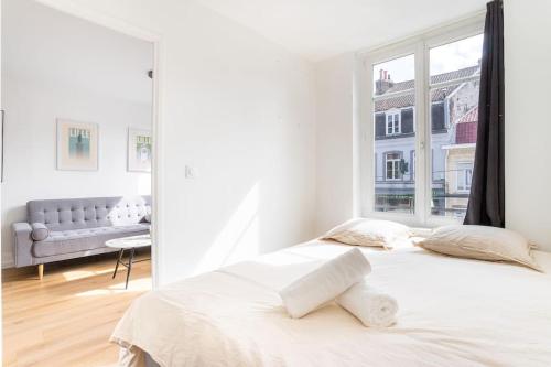 une chambre blanche avec un grand lit et une fenêtre dans l'établissement Bel Appartement Cosy proche du métro - Lille, à Lille