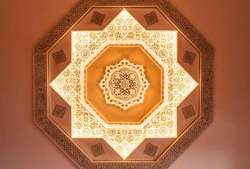 a ceiling of a building with a gold mandala at Alhambra Palace Hotel in Granada