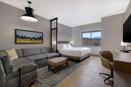 a living room with a couch and a bed at Hyatt Place Flagstaff in Flagstaff