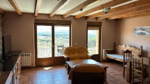 a living room with a chair and a balcony at Mirasierra II Y III in Navarredonda de Gredos