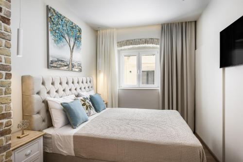 Spianada Collection of Studios & Apartments by Konnect في مدينة كورفو: غرفة نوم بسرير كبير مع وسائد زرقاء