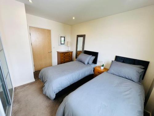 1 dormitorio con 2 camas y espejo en Stylish Zone 2 city Apartment, en Londres