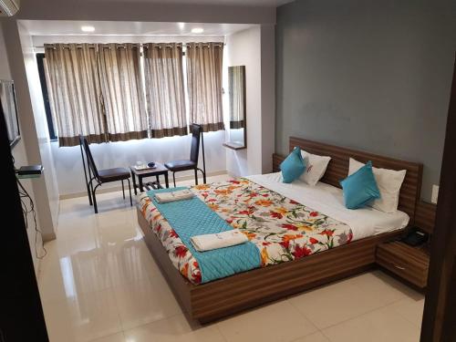 um quarto com uma cama, uma mesa e cadeiras em Hotel Dhruva-Solapur Pet friendly em Sholapur