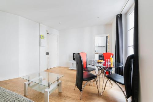 une salle à manger avec une table en verre et des chaises noires dans l'établissement 2 pieces renovee a neuf Paris 5 - 4P - FLAT-GUEST, à Paris