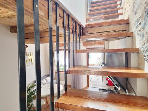 a spiral staircase in a house with wood and metal railings at Le Arcada - Appartamenti nel cuore del centro storico di Orosei in Orosei
