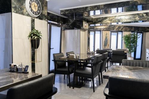 a dining room with a table and chairs and a clock at Avcı Palace Hotel in Istanbul