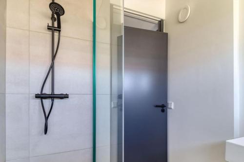 a shower with a glass door in a bathroom at Wijk de Brabander 134 in Cadzand