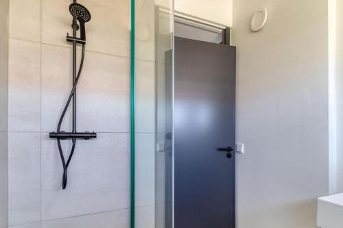 een douche met een glazen deur in een badkamer bij Wijk de Brabander 134 in Cadzand