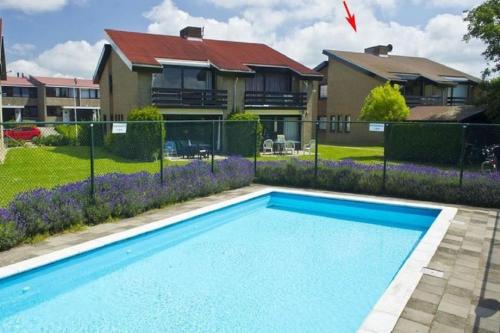 a swimming pool in front of a house at Wijk de Brabander 134 in Cadzand