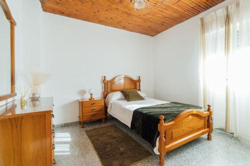 ein Schlafzimmer mit einem Holzbett und einer Kommode in der Unterkunft Casa Cuco in Corejido