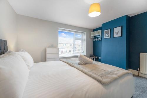 a bedroom with a large white bed with a blue wall at NEW! Stunning 2-Bed Home by Stay With Us, Ideal for Families, Sleeps 4! in High Etherley