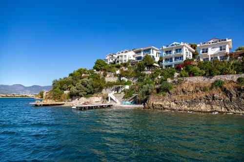 a group of houses on a hill next to the water at Sofia Ada in Fethiye