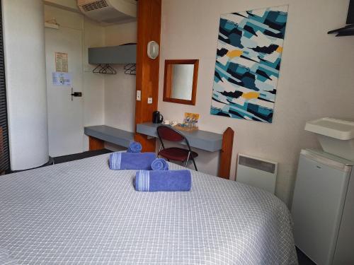 una camera da letto con un letto con asciugamani blu di Escale Kennedy a Mérignac