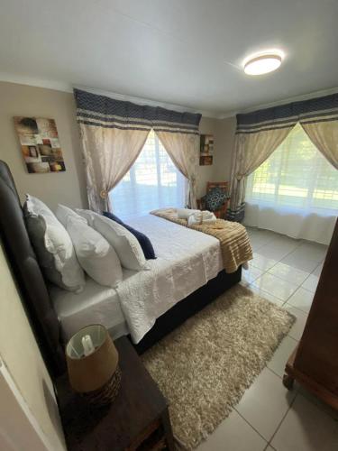 um quarto com uma cama e uma grande janela em The Lake Villa em Benoni
