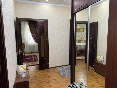 um quarto com uma porta e um espelho num quarto em Юнусабад шахристан люкс em Yunusobod