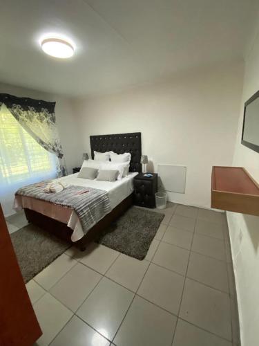Un dormitorio con una cama grande en una habitación. en The Lake Villa, en Benoni