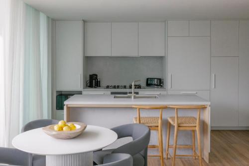 a kitchen with a table and chairs and a counter at Kirra Point Holiday Apartments in Gold Coast