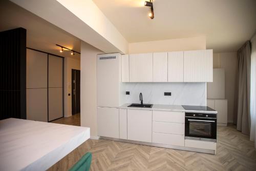 a kitchen with white cabinets and a stove at Sunset Studio - 12th Floor in Cluj-Napoca