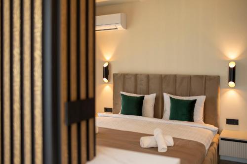 a bedroom with a bed with green and white pillows at Sunset Studio - 12th Floor in Cluj-Napoca