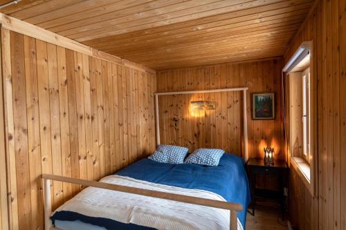 a bedroom with a bed in a wooden cabin at Private Island VESI - The White Blue Wilderness Lodge in Inari