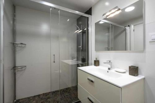 y baño blanco con lavabo y ducha. en Leo Apartamento familiar, en Alicante