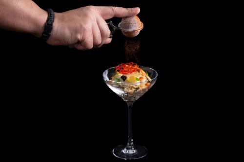 a person pouring food into a wine glass at Hôtel Saint-Alban in Nézignan-lʼÉvêque
