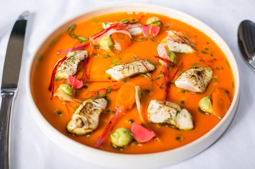 a bowl of soup with chicken and vegetables in it at Hôtel Saint-Alban in Nézignan-lʼÉvêque