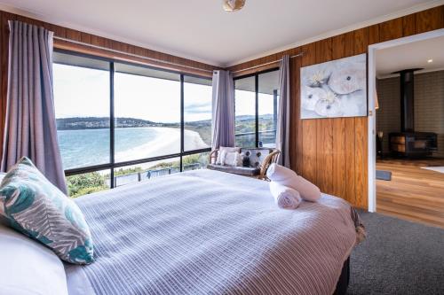 a bedroom with a bed with a view of the ocean at Stones Throw in Primrose Sands