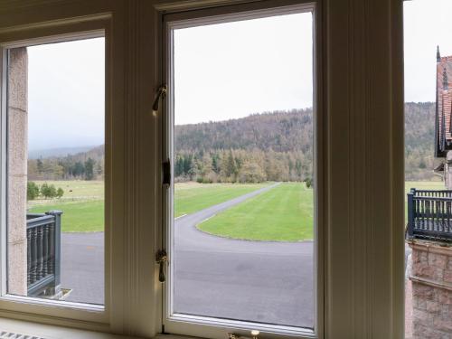 an open window with a view of a road at Dalvorar - Mar Lodge Estate in Ballater