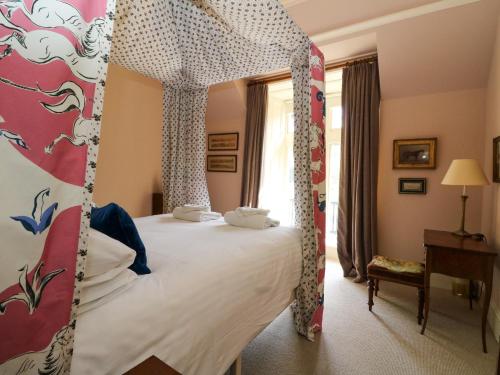 a bedroom with a four poster bed and a mirror at Dalvorar - Mar Lodge Estate in Ballater