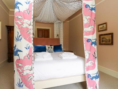 una camera con letto a baldacchino e lenzuola bianche di Dalvorar - Mar Lodge Estate a Ballater