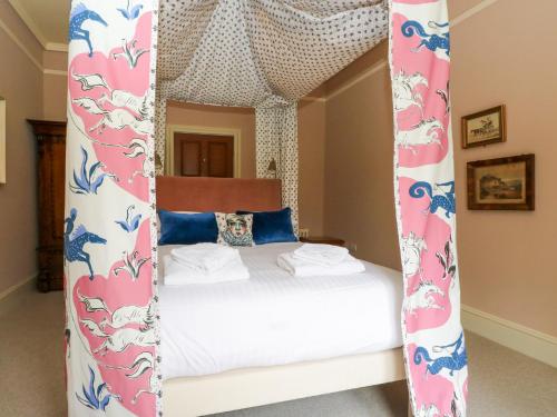 a bedroom with a canopy bed with white sheets at Dalvorar - Mar Lodge Estate in Ballater
