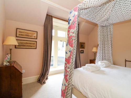 a bedroom with a canopy bed and a window at Dalvorar - Mar Lodge Estate in Ballater