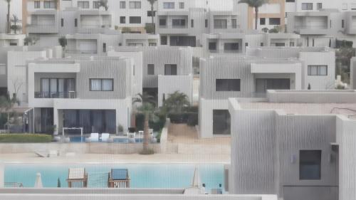 een groep witte gebouwen met een zwembad bij Sand Castle Private Villa in Azha Ain Sokhna in Ain Sokhna