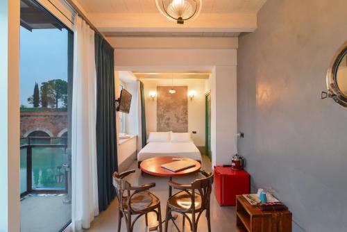 a room with a bed and a table and chairs at CABANON urban apartments in Peschiera del Garda