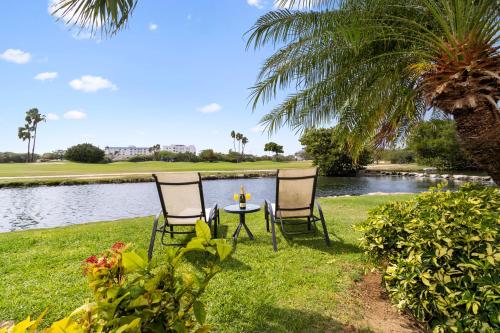 two chairs and a table in front of a lake at Divi Village Condo 6 J.E. Irausquin Blvd 93 in Palm-Eagle Beach