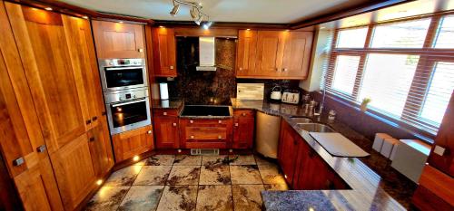 a kitchen with wooden cabinets and a stove top oven at Abbey Farm House Ormskirk in Ormskirk