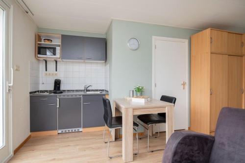 una pequeña cocina con mesa y sillas en una habitación en Casa Al Mare, en Zoutelande