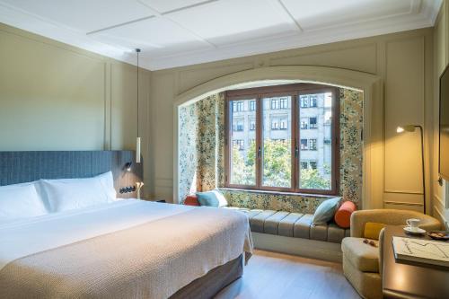 1 dormitorio con cama, ventana y sofá en El Avenida Palace, en Barcelona