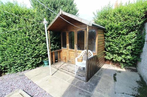 um pequeno barracão de madeira com uma cadeira em Hawkhill House em Leeds