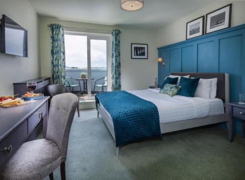 a bedroom with a bed with a blue headboard at Arklow Bay Hotel in Arklow
