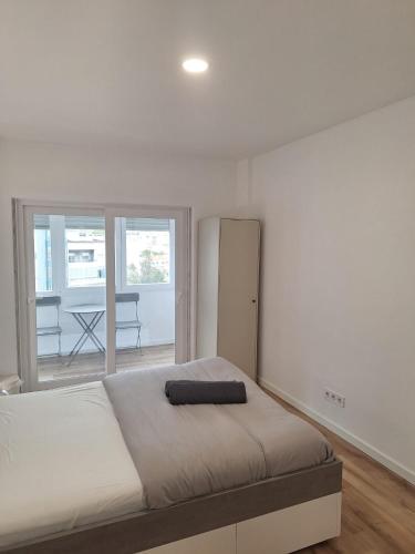 a bedroom with a large bed and a large window at Lisbon South Bay Rooms 2 in Almada