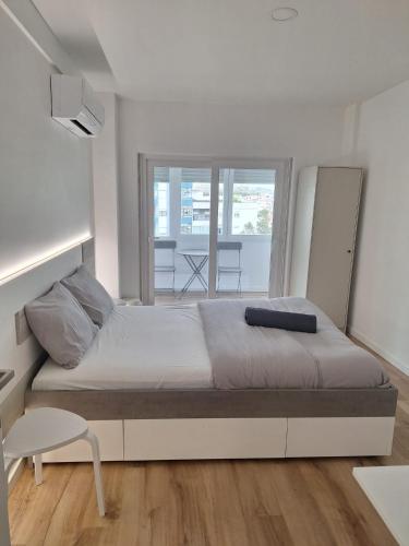 a bedroom with a large bed and a table at Lisbon South Bay Rooms 2 in Almada