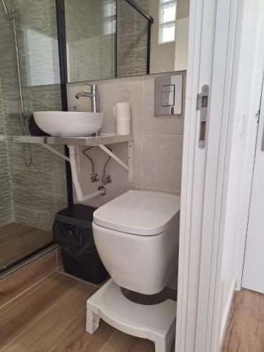 a bathroom with a white toilet and a sink at Lisbon South Bay Rooms 2 in Almada